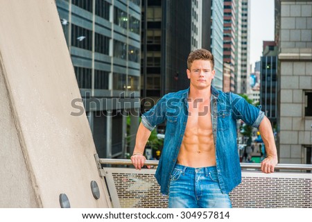 Yes, We can. Wearing Denim shirt, unbuttoned, showing strong body, a young sexy guy standing on balcony, facing street in New York, confident, successful, ready to work. Portrait of Hard Worker.