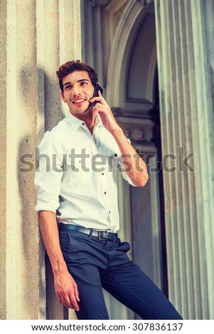 Businessman Working in New York. Wearing white shirt, black pants, a young college student talking on mobile phone outside office building. Concept of technology in daily life, Instagram filtered look