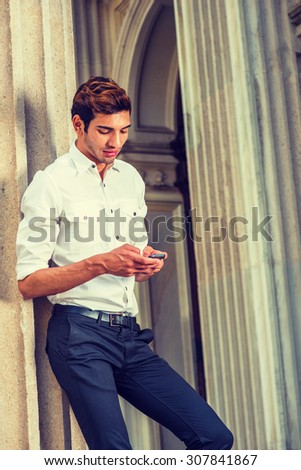 Businessman Working in New York. Wearing white shirt, black pants, a college student reading messages on mobile phone outside office building. Concept of technology in daily life, Instagram effect.