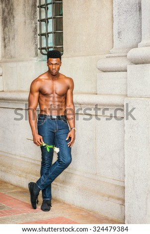 African American Man seeking love in New York. Shirtless, half naked, waring blue jeans, holding a white rose, a young, strong, sexy guy standing by wall on street, waiting for you. I missing you.
