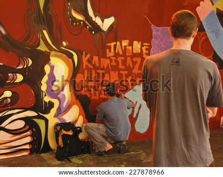 SAO PAULO, BRAZIL, JANUARY 27, 2007: Graffiti artist works on his creation on street.