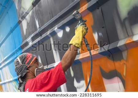 SAO PAULO, BRAZIL, OCTOBER 11, 2011: Graffiti artist works on his creation on street.