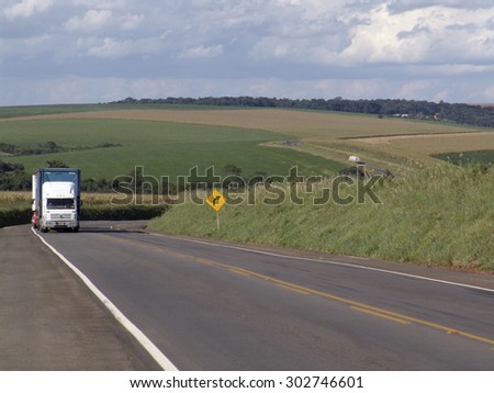 Rio Grande do Sul, Brazil - February 11, 2006: Green soy field with country road on which is moving the truck.