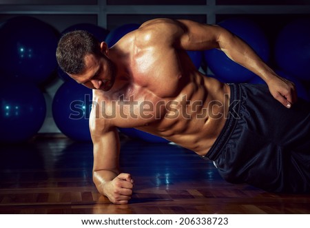 Man doing side plank exercise in gym