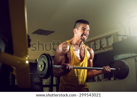Yougn teenage man doing barbell exercise in gym