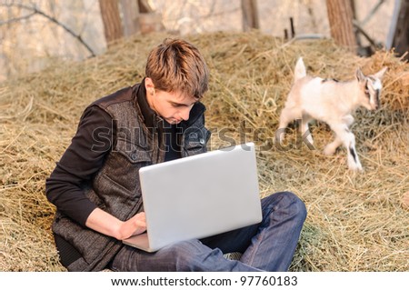 Rural laptop work with a small goat