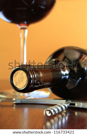 Close up of a red wine bottle with steel corkscrew