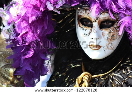 VENICE - FEB 16 : Rich feathered purple mask portrait during Venice Carnival on February 16 , 2012 . Approximately  3 million visitors come to Venice every year for Carnivals.