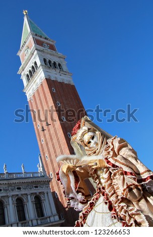 VENICE - FEBRUARY 17: Elegant mask and bell  tower during Venice Carnival on February 17 , 2012 in Venice , Italy . Approximately  3 million visitors come to Venice every year for Carnivals.