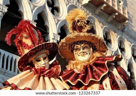 VENICE - FEBRUARY 17: Colorful masked couple during Venice Carnival on February 17 , 2012 in Venice , Italy . Approximately  3 million visitors come to Venice every year for Carnivals.