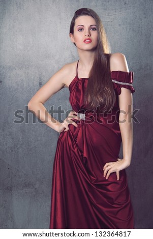 Beautiful fashion model in elegant dress made of red silk. Elegance and fashion portrait
