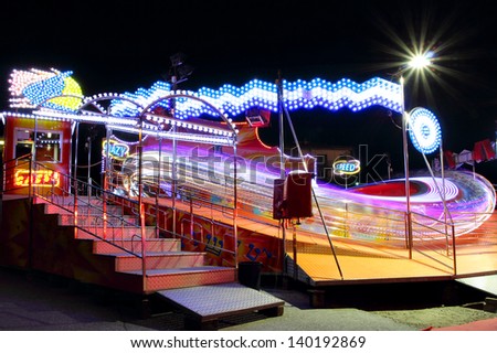 Very fast carousel in motion full of lights and colors