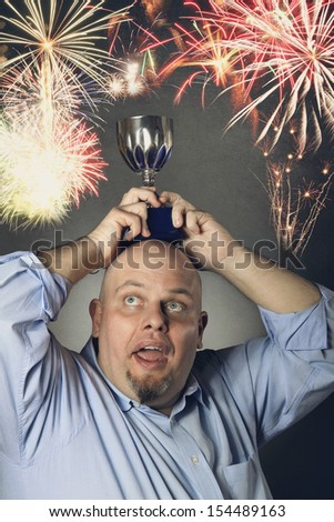 Man with winning trophy over his head and fireworks in background . Success conceptual