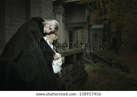 Vampire lady embraces her victim . Horror and Halloween concept