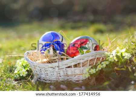 Easter eggs hand painted in a wicker basket . Natural spring light