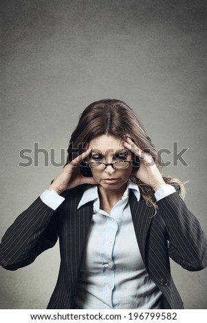 Businesswoman with hands to the forehead. Deep thinking or headache