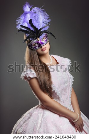Beautiful woman in pink historical dress with purple venetian mask . Venice carnival portrait