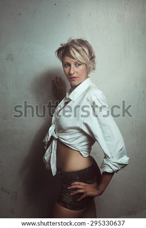Beautiful short hair woman posing against a wall . Urban portrait