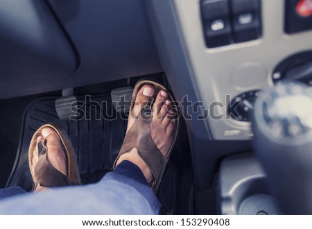 Male feet on the pedals of a car