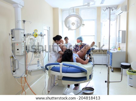 Sofia, Bulgaria,July 7, 2014 : Woman gives birth in a Delivery room with the help of doctor and nurses in The University Obstetrics and Gynecology Hospital