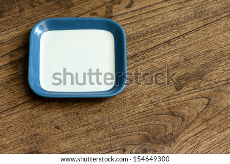 empty square white and blue color dish on wood table