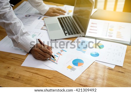 a businessman working plan the business and analysis many chart graph vintage tone sunlight