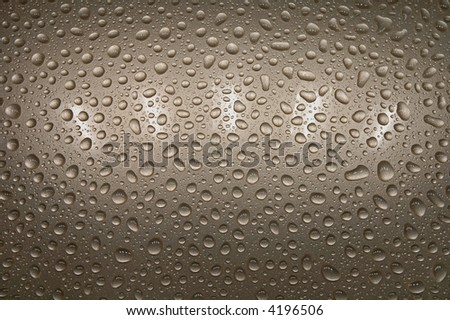 Water droplets on a golden metallic surface