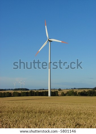 Giant wind turbine on a hilly field