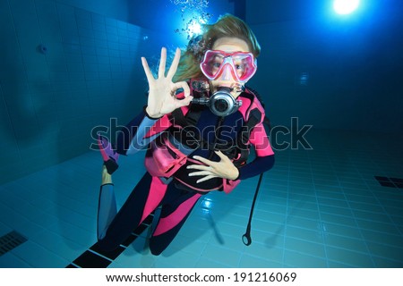 Female scuba diver smiling underwater in the pool