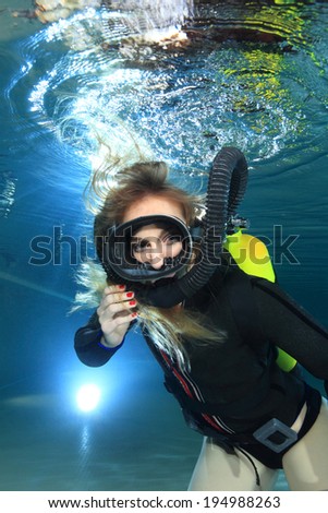 Scuba woman with black neoprene dress diving underwater