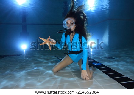 Scuba woman with lycra dive suit and sea star underwater in the pool