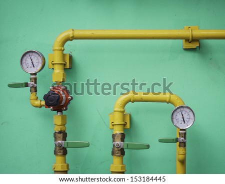 Yellow gas meter against blue wall