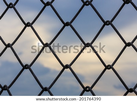 Wire Mesh Fence on storm clouds background