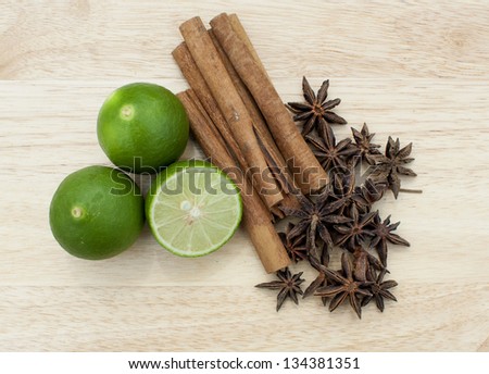 Anise and cinnamon spices with lime on wooden chopping board