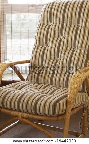 Beautiful bedroom interior with cane chair and bamboo blinds in the background. Warm tone