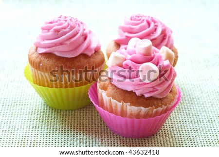 اروع تشكيلة لمحبي الكاب كيك Stock-photo-small-vanilla-cupcakes-with-strawberry-icing-and-marshmallows-on-green-mesh-background-43632418