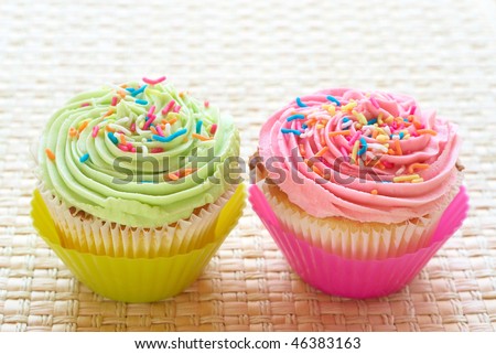 اروع تشكيلة لمحبي الكاب كيك Stock-photo-fresh-vanilla-cupcakes-with-strawberry-and-lime-icing-on-woven-straw-background-46383163