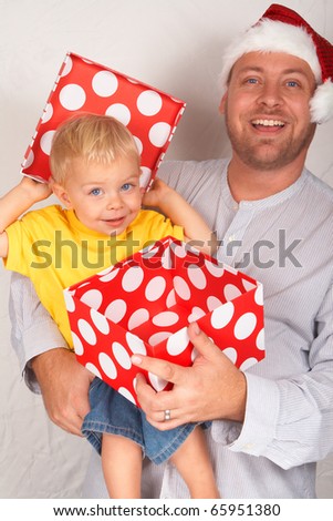Baby boy with his father for Christmas holding a large gift box