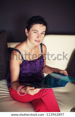 woman read magazine on sofa in living room