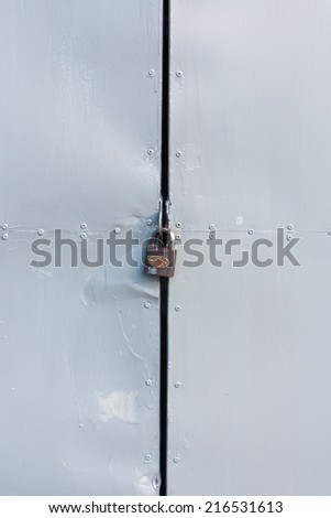 The gray door made from zinc plate has locked, vertical style