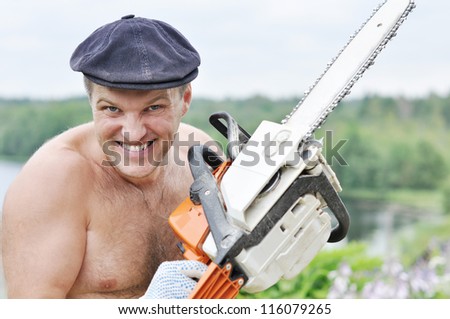 Expressive man with electric saw on nature background