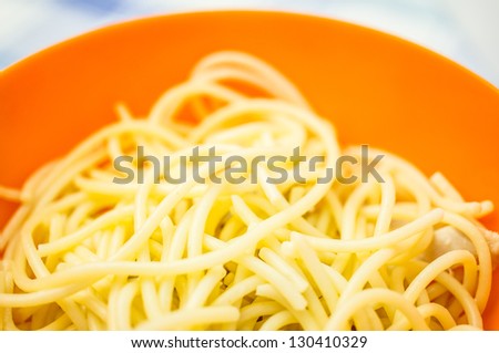 Pasta with chicken in an orange bowl