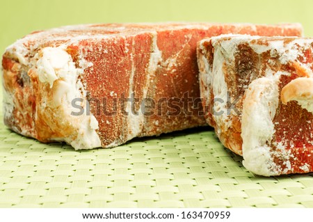 Frozen meat. Two pieces of frozen beef meat on a green background.
