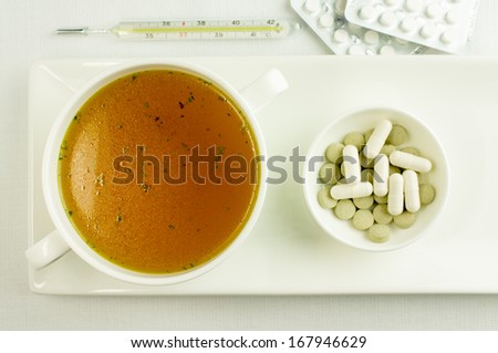 Broth, bouillon, clear soup  to treat colds. Background pills, drugs, thermometer.