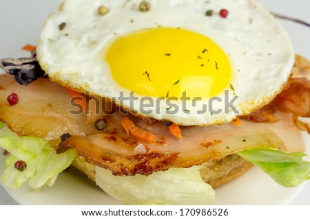 Burger with fried eggs and bacon salad