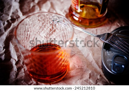 Shot with cognac, brandy on the table in dim lighting