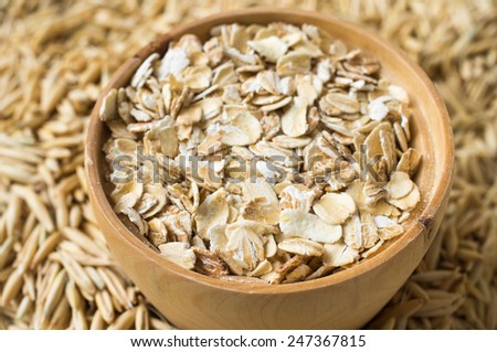 Rolled oats and oats in a wooden bowl