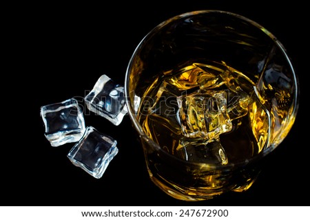 Bourbon whiskey with ice on a black background