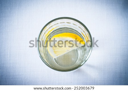 Glass of clean water with a slice of lemon view from above