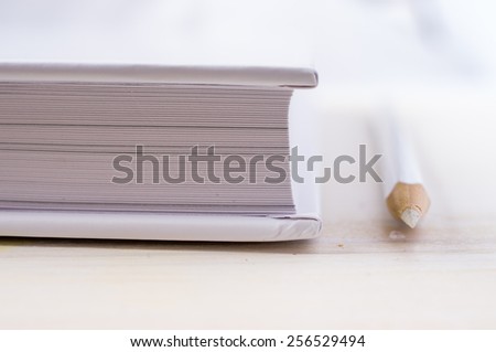 White book and white pencil next